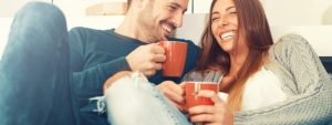 Happy young couple sitting on a sofa discussing mortgages and the stamp duty holiday