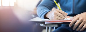 Student in a class room studying hard after A Level controversary, there are bumpy roads ahead