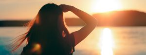 A lady looking out over the horizon of sea at a glimmer of hope for the New Year