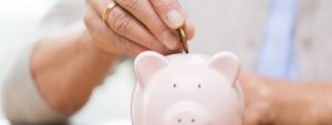 woman’s hand putting money to piggy bank, secret savings