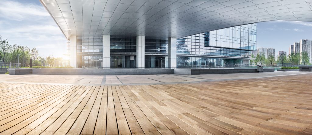 Exterior of modern glass office building, , with wooden floor foreground