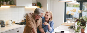 Senior couple in kitchen with paper and laptop going through finances, Bank of Mum and Dad