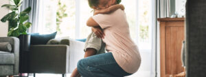 Lady hugging her daughter at home in the living room, one of sandwich generation facing challenges and seeking support