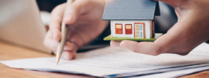 Mortgage adviser holding a model house, looking at mortgage deals for clients, unaffordable