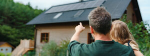 Father and daughter looking at solar panels on house, extra green home improvements on hold