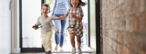 Excited Children Arriving Home With Parents