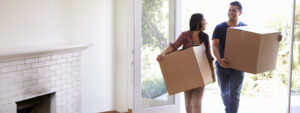 Couple Carrying Boxes Into New Home On Moving Day