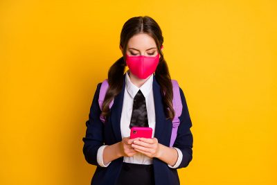 School girl wearing a face mask ready to go back to school, with Covid19 safety measures in place.