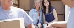 Young couple, first-time buyers moving into house, surrounded by boxes, getting parental support