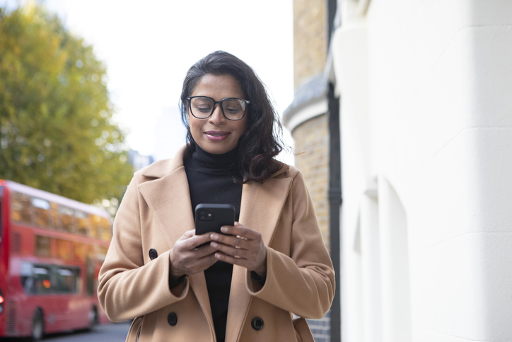 woman looking at her investments on a smart phone