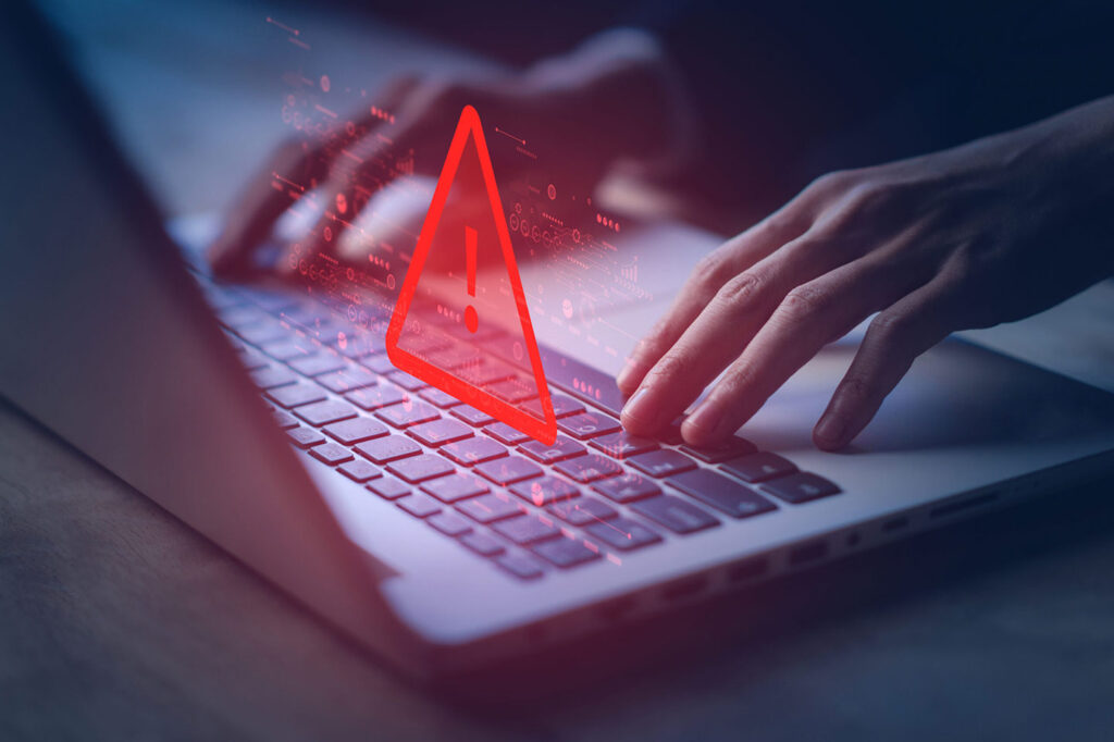 laptop with warning sign, highlighting cloning scam